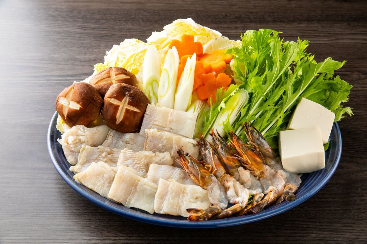 大分県産の車海老と鱧の切り身を、旬の野菜と共に皿に美しく盛り付けたしゃぶしゃぶセットの画像。自宅で贅沢な海鮮鍋パーティーを楽しめます。