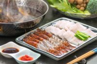 大分県産車海老と鱧のしゃぶしゃぶを調理し、温かい出汁と共に、食卓の皿に盛り付けた画像。冬のギフトやお歳暮に最適な、豪華な海鮮しゃぶしゃぶセット。