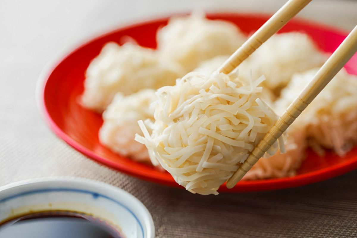 ふっくら蒸し上がった「勝ちえびしゅうまい」を、箸で持ち上げ、醤油につけようとしているアップ画像。海老の旨味が詰まった大分のご当地しゅうまい。