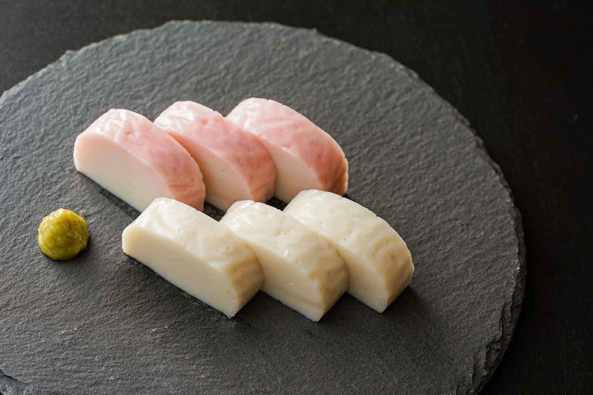 紅白の美しい彩りがわかるようにカットして皿に盛り付けられたかまぼこの画像。お祝い事やおせち料理に最適な大分県産のかまぼこ。