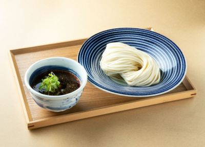 天然クロメのつけダレと、美しい麺線が整えられたつけそばがお盆に並んだ画像。大分特産の天然クロメの風味を、蕎麦と一緒に楽しめる完成品のイメージ。