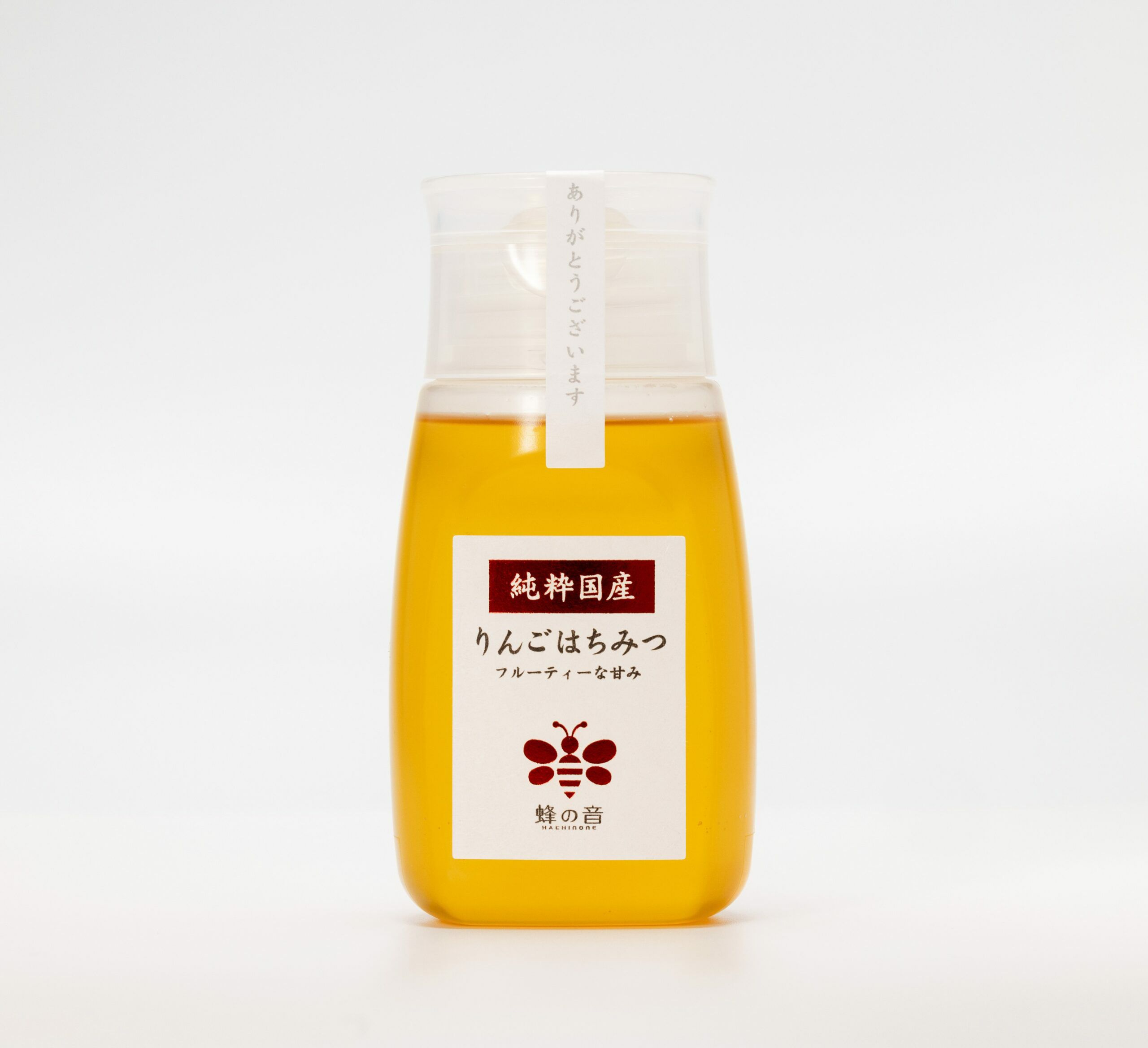 りんごの花を蜜源とした「国産りんごはちみつ」の画像。やや濃いめの黄色で、りんごの優しい甘さとほのかな酸味、フローラルな芳香が特徴の国産はちみつ。