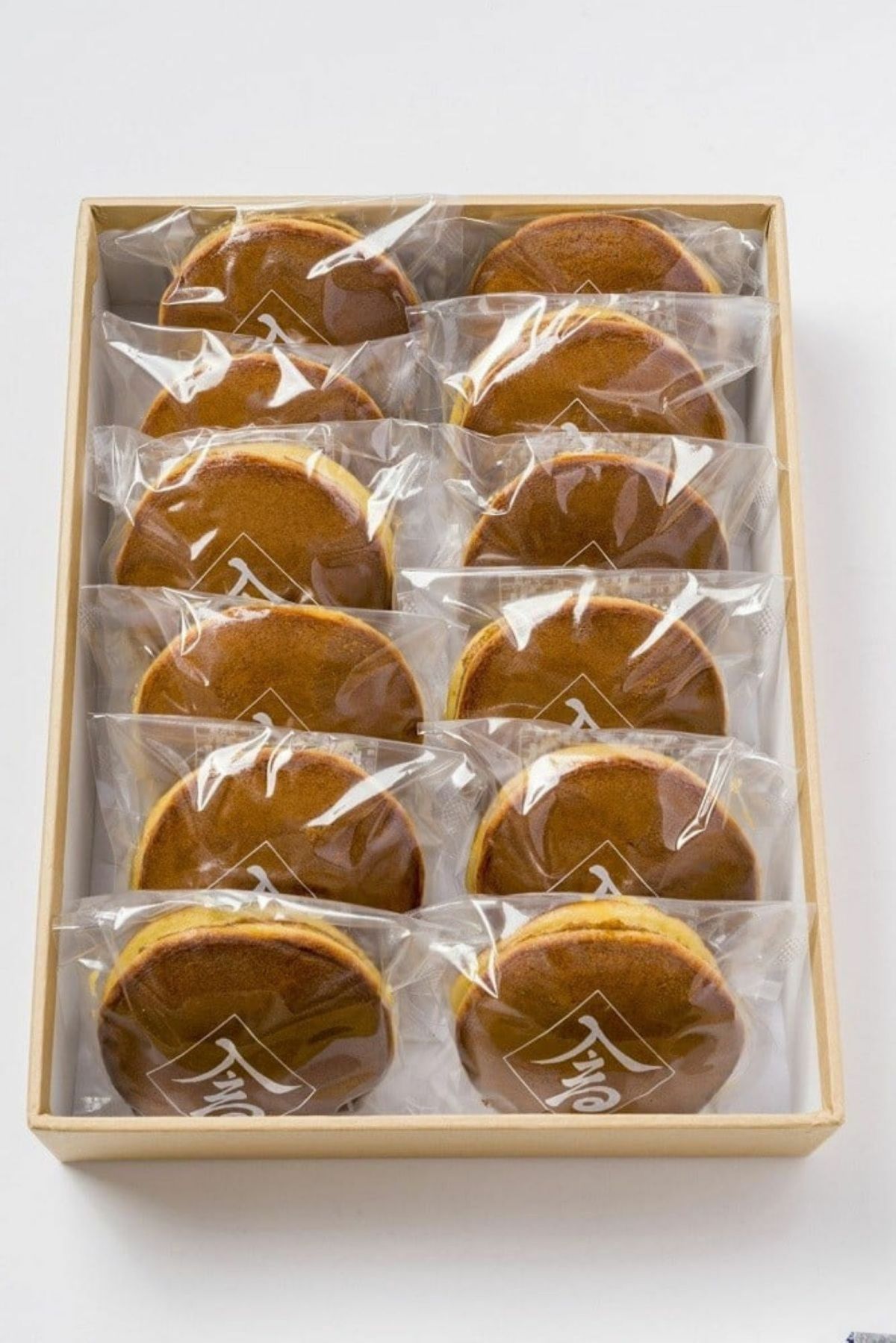 「昭和の町高田屋のどら焼き 12個入り」のギフト箱に、素材にこだわったどら焼きが詰められた内容量画像。贈答やお土産に最適な、自家製餡の和菓子セット。