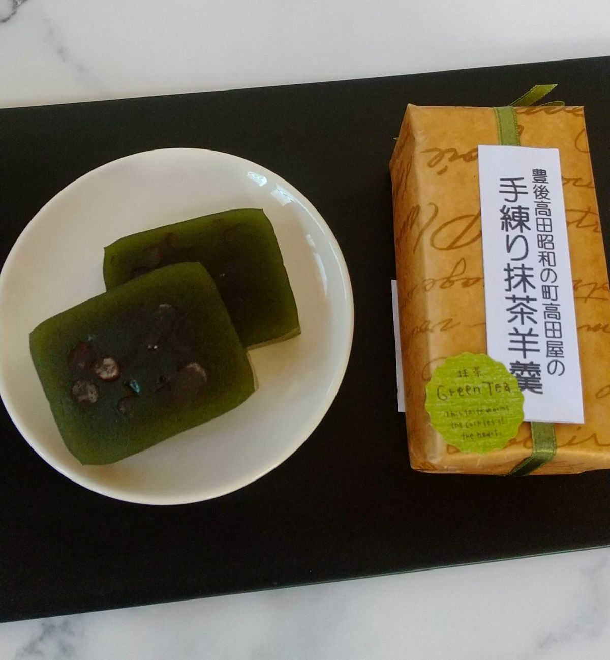 「手練り羊羹 3本セット」に含まれる「大納言入り抹茶羊羹」の商品画像。抹茶の豊かな風味と、大納言小豆の優しい甘さが特徴の本格手練り羊羹。