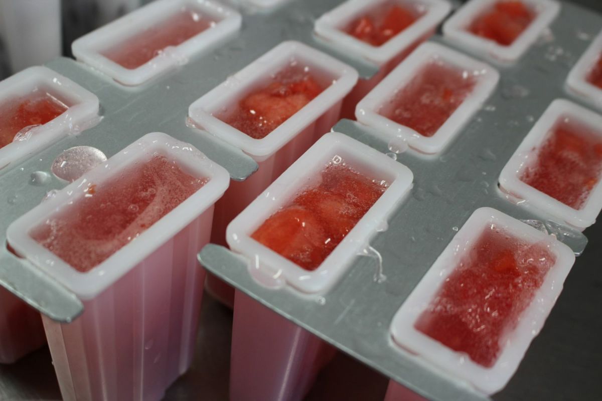 溶けないアイスキャンデーの生地を、アイスの型に流し込んでいる製造工程の画像。葛と果肉を混ぜた、もちシャリ食感を生み出す特別な工程。