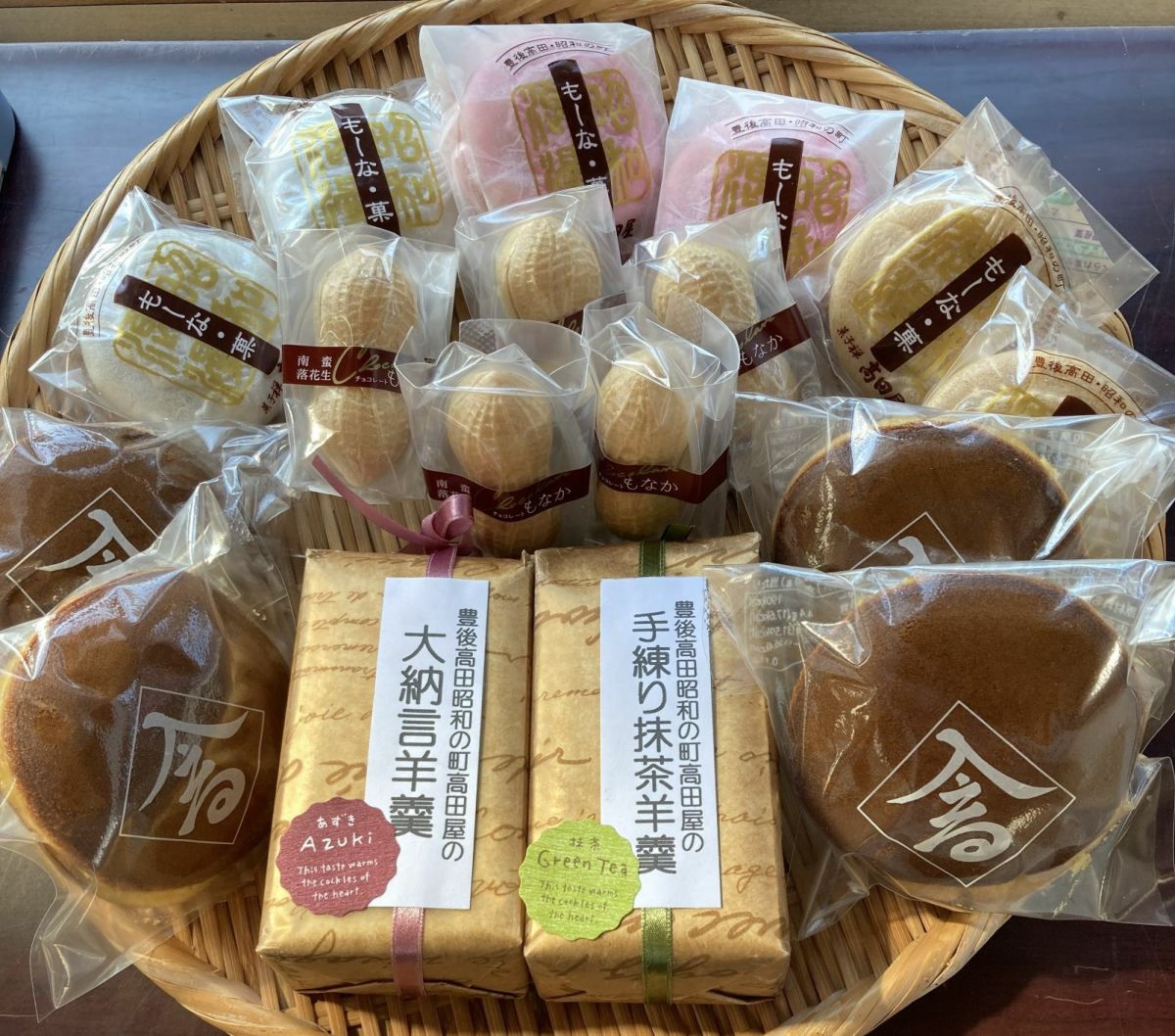 昭和の町高田屋の「高田屋スペシャルセット」の詰め合わせ商品を、木ざるに彩りよく並べた画像。自家製餡が自慢のどら焼き、も～な・菓、南蛮もなか、本格手練り羊羹など、和菓子が豊富。
