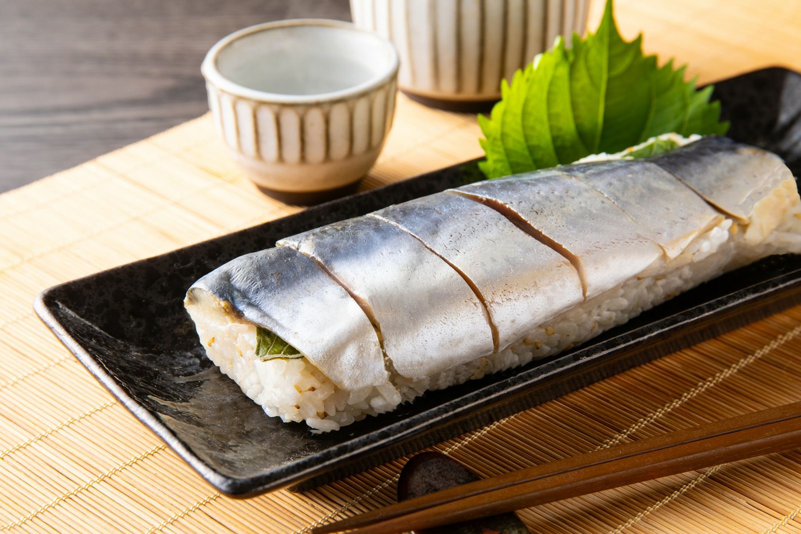 大分県のブランド魚「関さば」を使用した棒寿司をカットして皿に盛り付けた画像。解凍するだけで楽しめる、ご贈答にも最適な通販の押し寿司。
