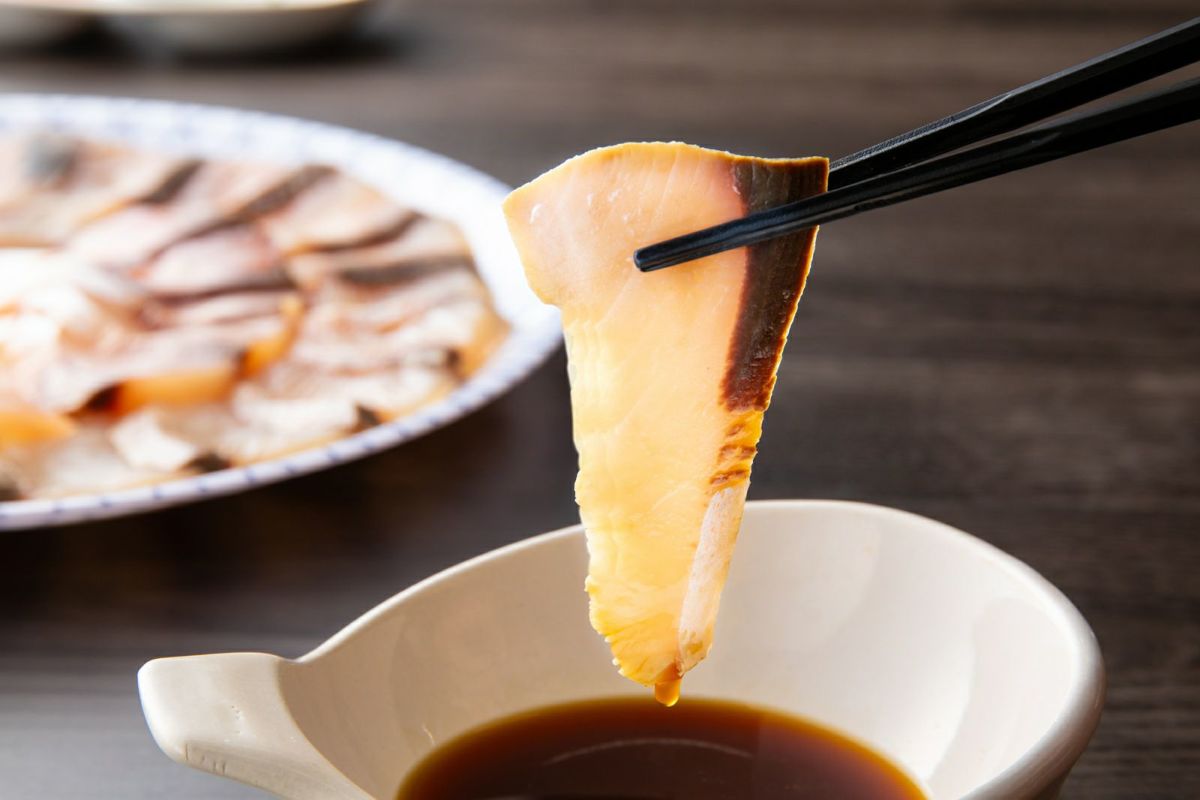 しゃぶしゃぶにした関ぶりをポン酢につけている画像。身が締まってプリプリの天然一本釣り関ぶりの食感が伝わる、大分からの産地直送品。