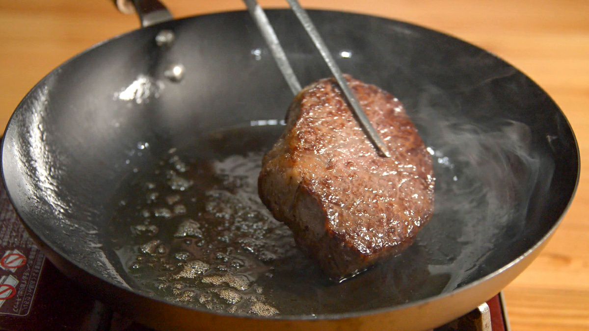 大分県産「おおいた和牛ヒレステーキ」を中華鍋で多めの油を使って焼いている調理中の画像。形が不揃いでも美味しく焼ける、高級ヒレ肉の調理風景。