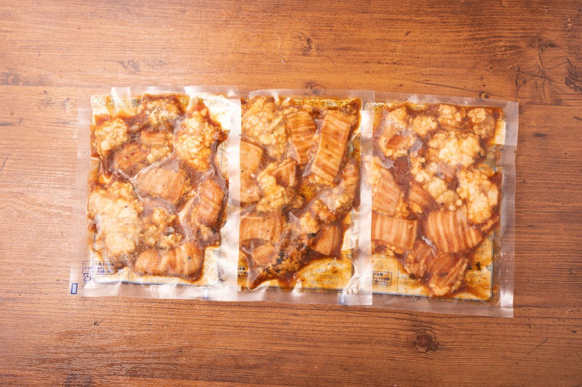 「元祖ホルモン丼の具」のレトルトパックが複数並んだ内容量画像。ご家庭で手軽に元祖の味が楽しめる、便利な冷凍または冷蔵のお取り寄せセット。