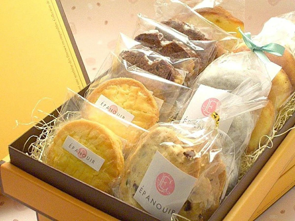 「エパヌイールの焼き菓子詰合せ」のギフト箱に、マドレーヌ5個、ショコラネージュ6個、チョコチップクッキー6枚、ケークショコラ3個、オレンジケーキ2個、ガレット2個が詰められた内容量画像。