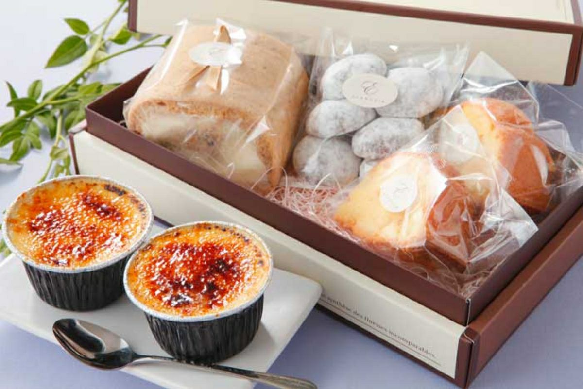 「ロール・プリン・焼き菓子の詰合せ ダリア」のギフト箱に、湯の香プリン2個、シフォンロール1本、ショコラネージュ5個、オレンジケーキ2個が詰められた内容量画像。