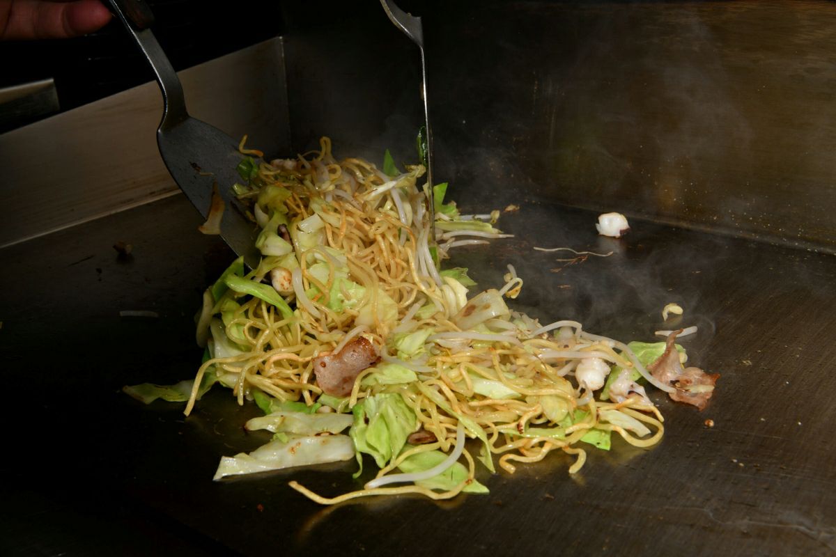 「和風野菜ちゃんぽん」の麺とたっぷりな野菜を、鉄板で一緒に炒めている調理中の画像。香ばしいちゃんぽん麺を作る工程。