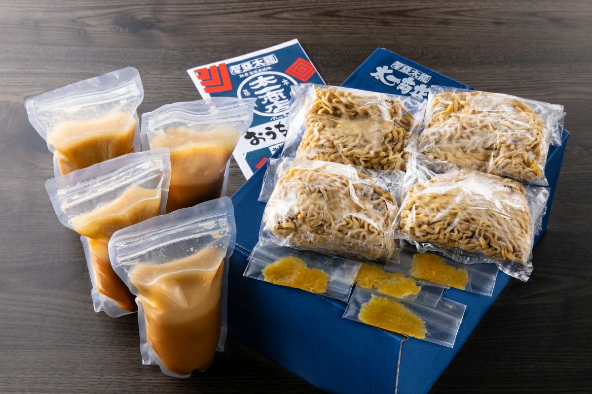 「太一商店ラーメン4食セット」の内容量画像。極太麺、チャーシュー入り濃厚スープ、にんにく、作り方説明書が個別にパック詰めされている。
